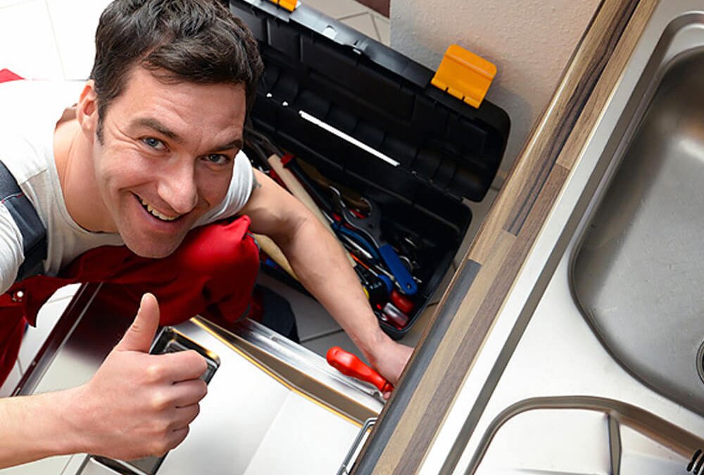 Monteur arbeitet mit Werkzeug an einer Küche neben der Spüle