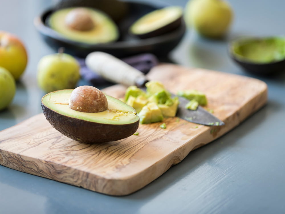 Reife Avocado mit braunem Kern auf einem Schneidebrett in der Küche