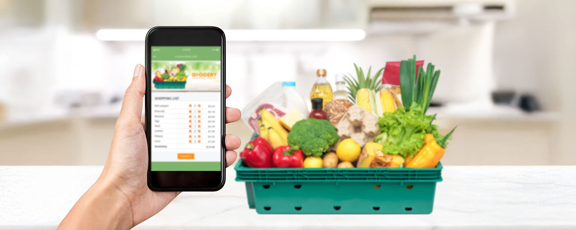 Smartphone mit digitaler Einkaufsliste neben vollem Einkaufskorb – Kühlschrank Organisation und Lebensmittelvorrat im Blick