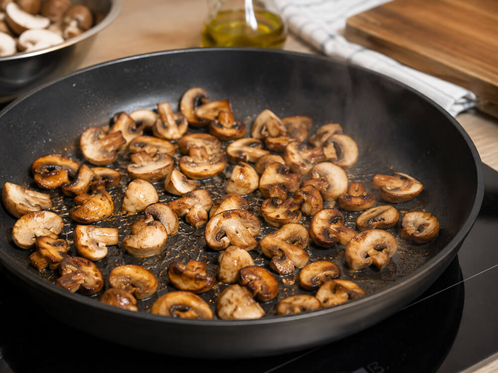 Champignons und Pfifferlinge werden in einer heißen Pfanne goldbraun angebraten