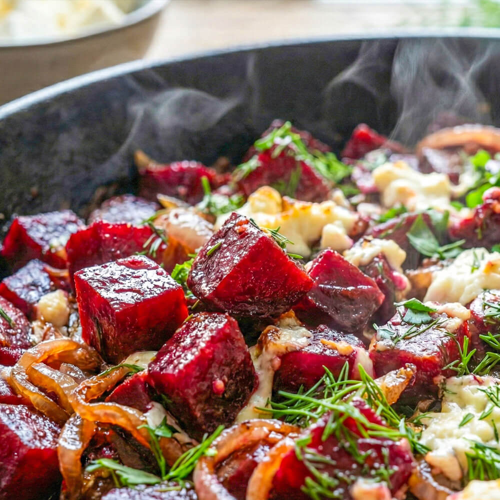Rote-Bete-Pfanne mit Zwiebeln und Feta in einer gusseisernen Pfanne serviert, als einfaches vegetarisches Pfannengericht.