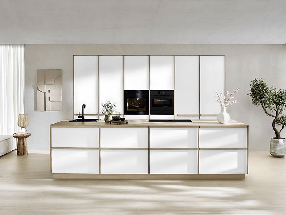 Großzügige Japandi Küche mit weißen Fronten, Eiche-Como-Details und zwei AEG-Backöfen auf Augenhöhe