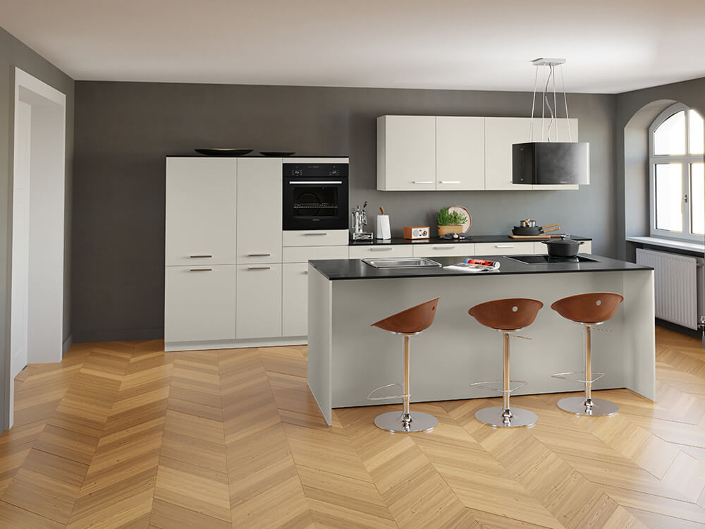 Moderne Inselküche in Sandoptik mit schwarzer Arbeitsplatte, Siemens-Backofen und Frühstückstheke mit Barhockern