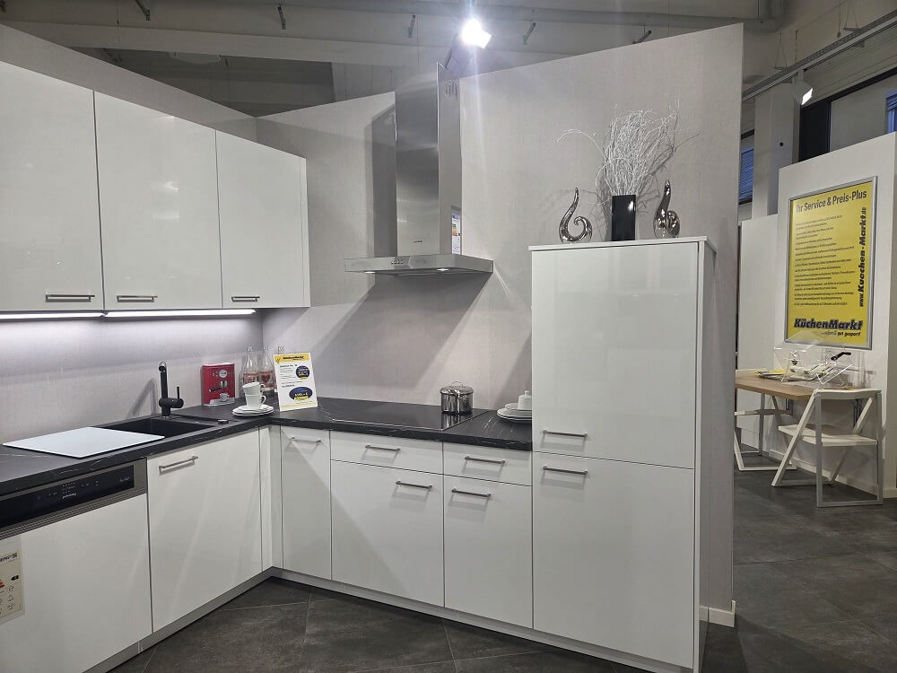 Weitwinkel-Ansicht der U-Küche Touch, die den Spülbereich, Vitrinenschränke und die Theken-Wange in Holz-Optik zeigt.