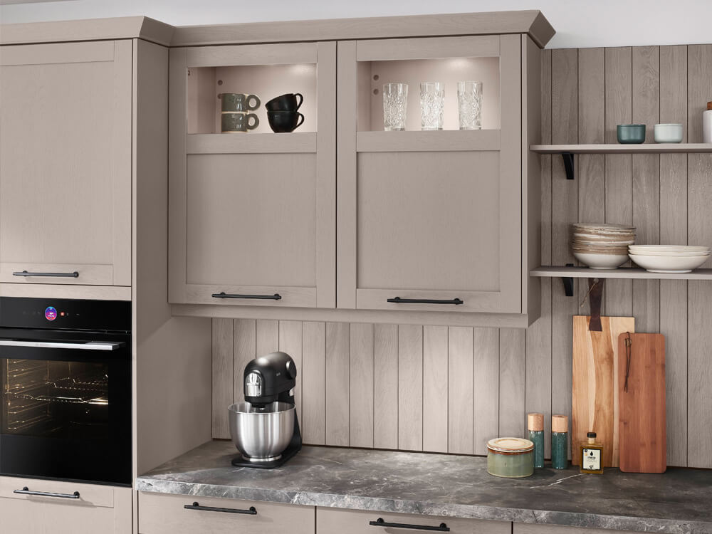 Graue Küchenschränke mit beleuchteter Glasvitrine und Arbeitsplatte in dunkler Steinoptik