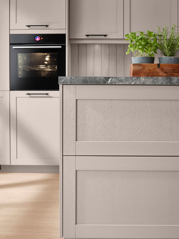 Nahaufnahme graue Küche in Holzoptik mit strukturierter Rahmenfront und schwarzem Backofen