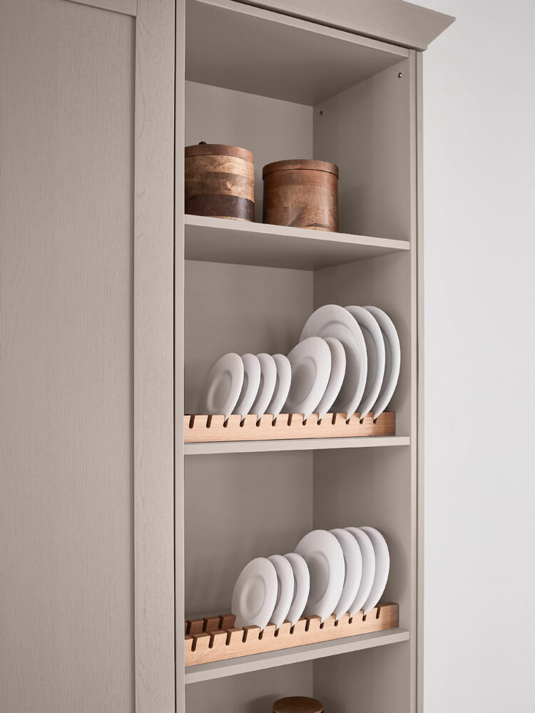 Vertikaler Tellerhalter aus Holz im Regal einer modernen Einbauküche