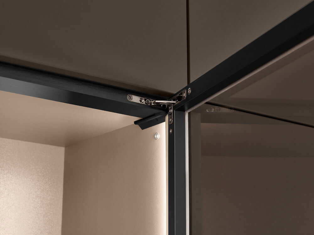 Detailaufnahme eines hochwertigen Scharniers an matten, grifflosen Küchenfronten