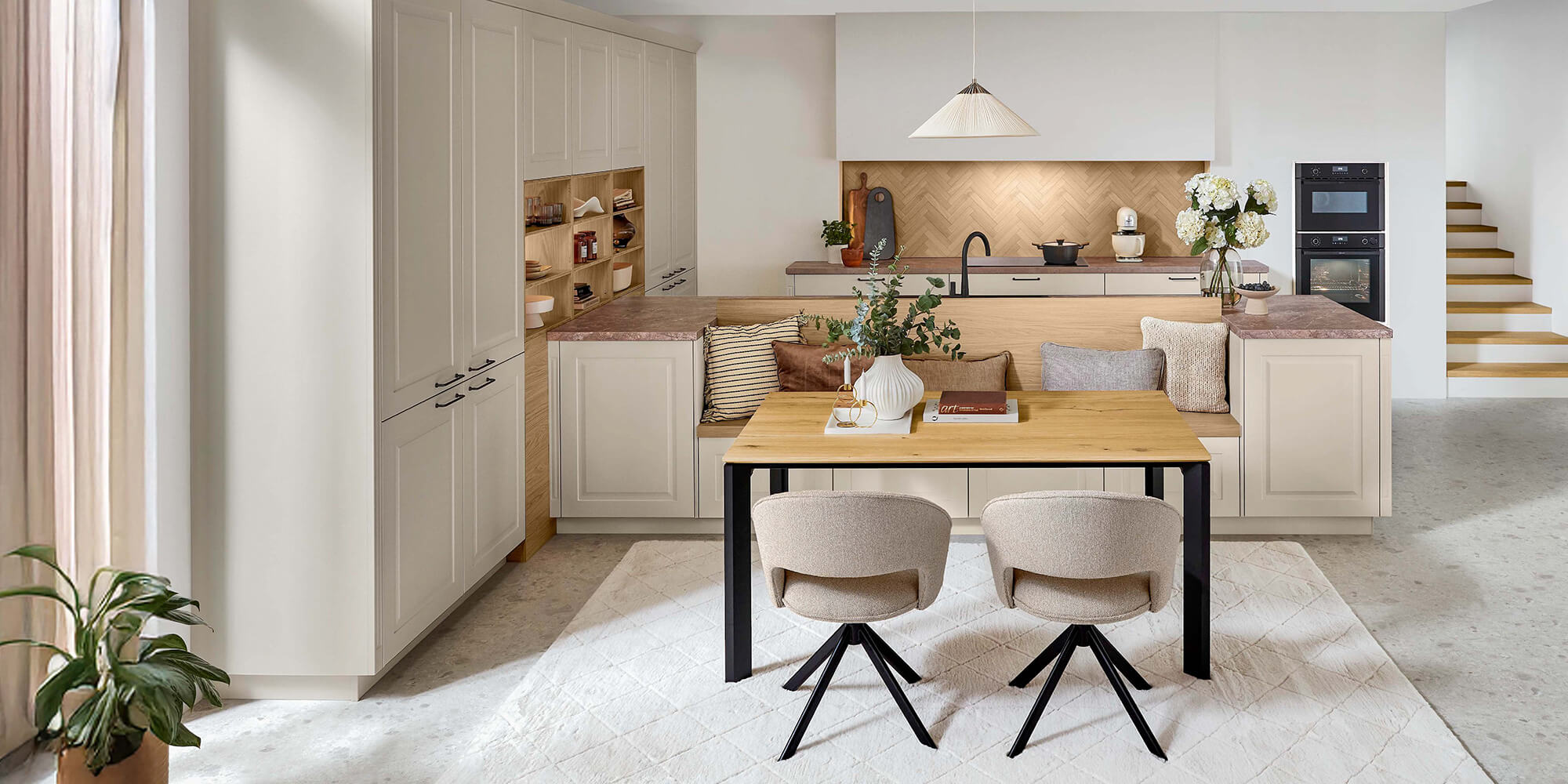 Landhausküche modern Sylt 848 als offene Wohnküche im Landhausstil mit Insel-Sitzbank und hellen Kassettenfronten